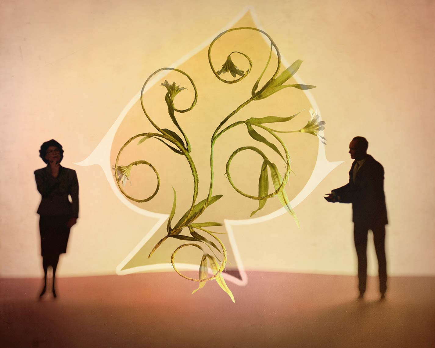 Silhouettes of a male and female business figures, on either side of a network of curving vines, suggesting communication.