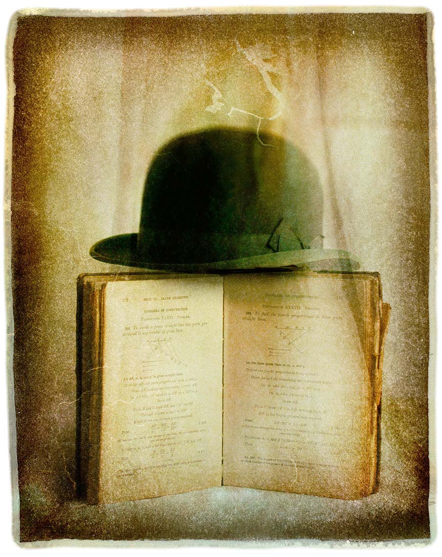 Bowler hat balancing on open book against soft-focus painterly mottled background of sepia colors.
