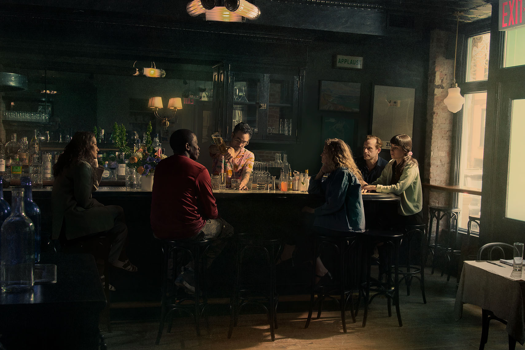 Small group of attractive people in their twenties and thirties enjoying drinks in an old-fashioned bar in the late afternoon.