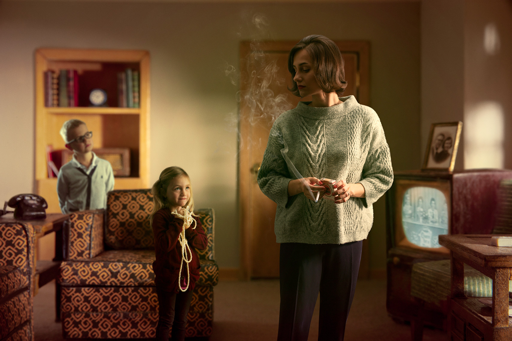 1960s re-creation of distracted mother smoking in suburban living room as her two children look on.