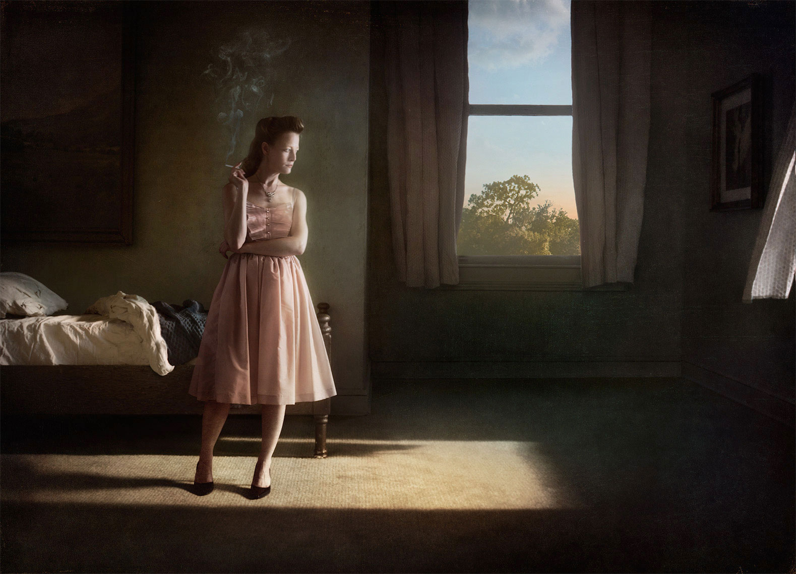A photomontage homage to Edward Hopper, set in a 1940s’ bedroom, a dishwater-blonde woman wearing a pale pink spaghetti-strap dress, stands in a rectangle of bright sunlight, holding a lit cigarette, and gazing solemnly out the window, an unmade bed in the background.